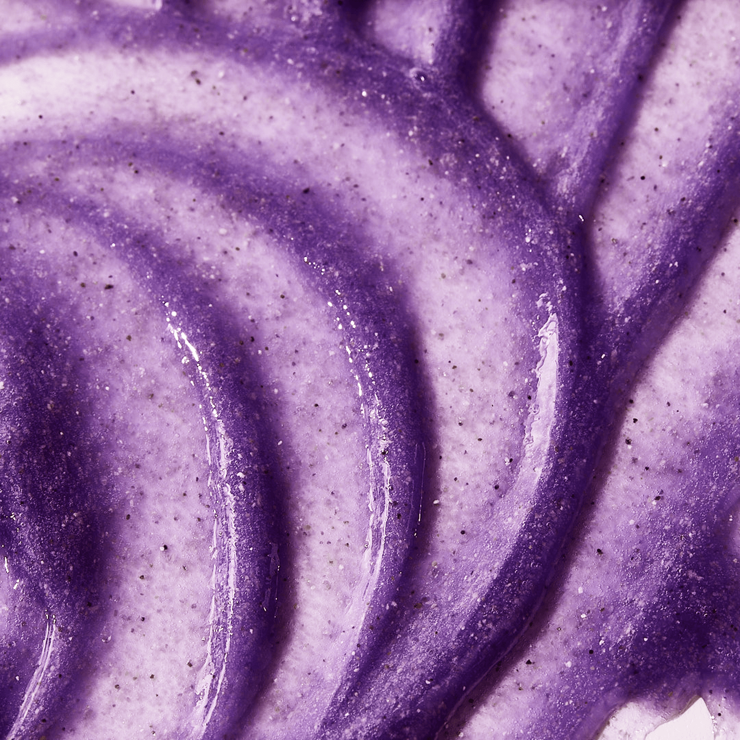 Close-up texture image of goPure Refine & Renew Body Scrub showing a rich, creamy purple formula with visible exfoliating granules and smooth swirled application.