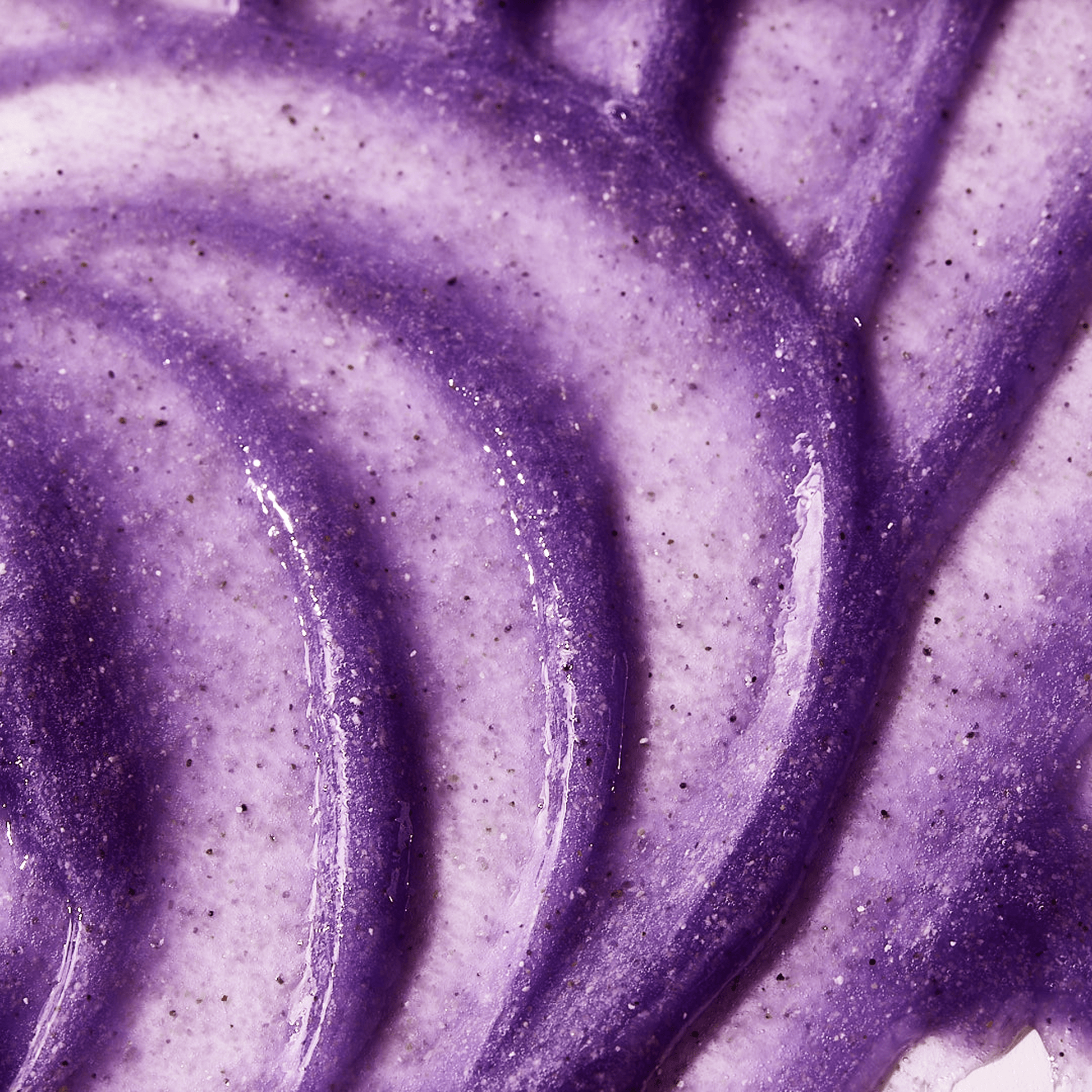 Close-up texture image of goPure Refine & Renew Body Scrub showing a rich, creamy purple formula with visible exfoliating granules and smooth swirled application.