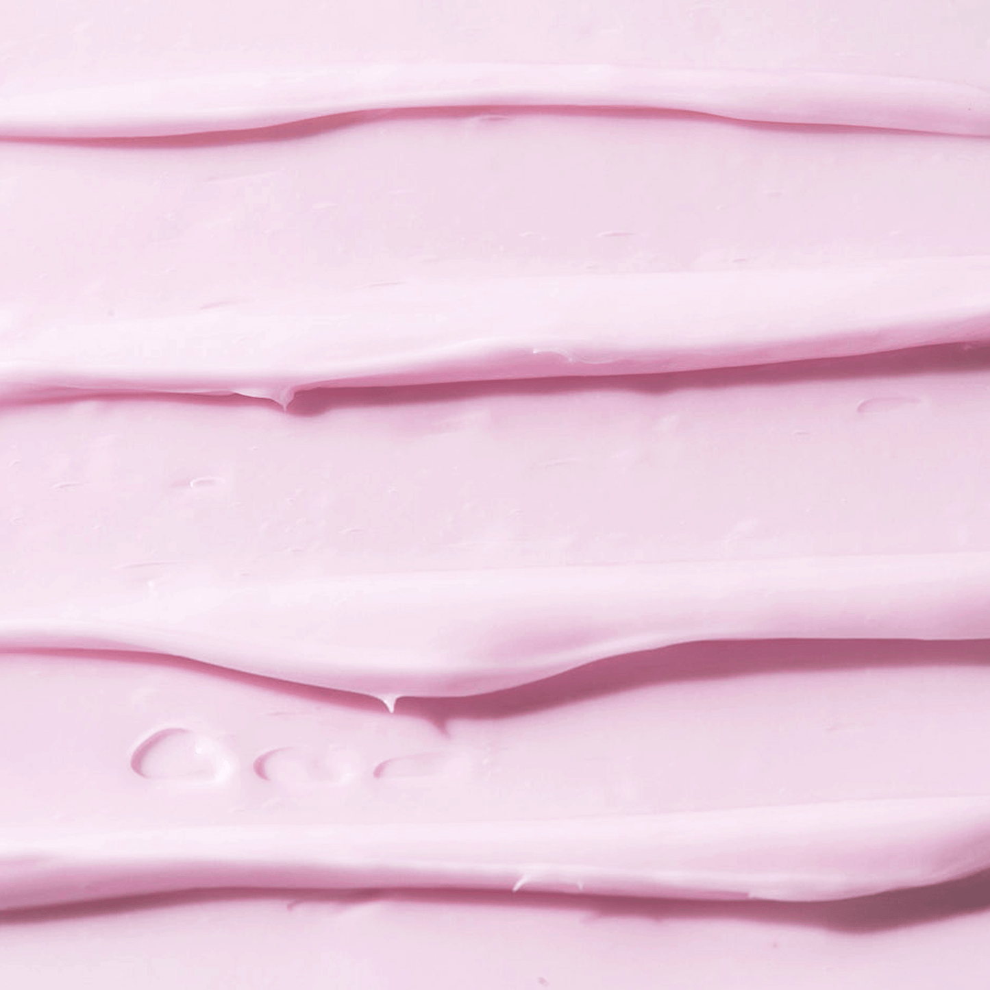 Close-up texture of light pink cream spread in smooth, even layers with a glossy finish.