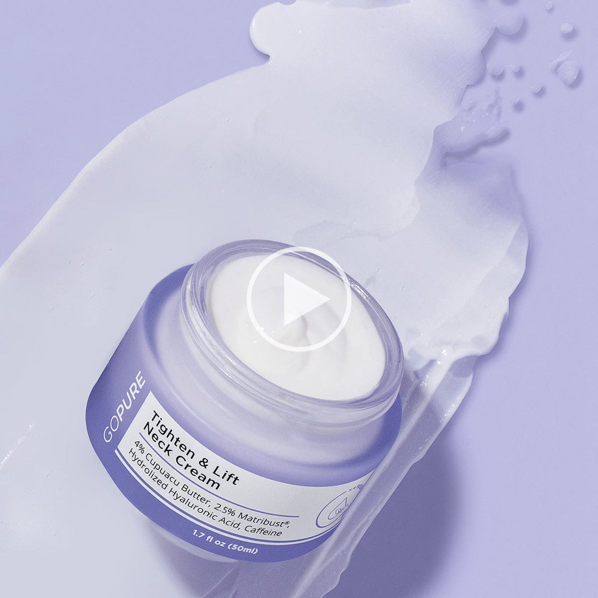 GoPure Tighten & Lift Neck Cream in an open purple jar with cream spilled around it on a purple surface. The label highlights 4% Cupuacu Butter, 2.5% Matrixyl®, Hydrolyzed Hyaluronic Acid, and Caffeine.