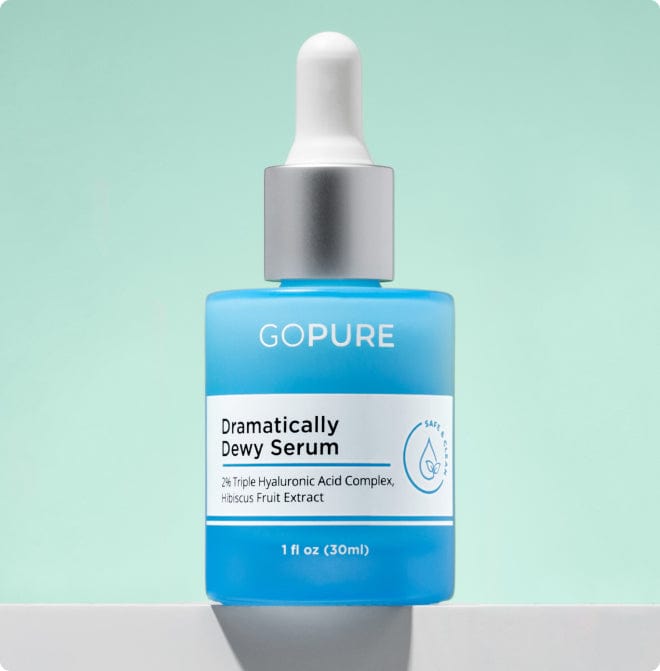GoPure Dramatically Dewy Serum bottle with dropper, featuring 2% Triple Hyaluronic Acid Complex and Hibiscus Fruit Extract, on a light green background.