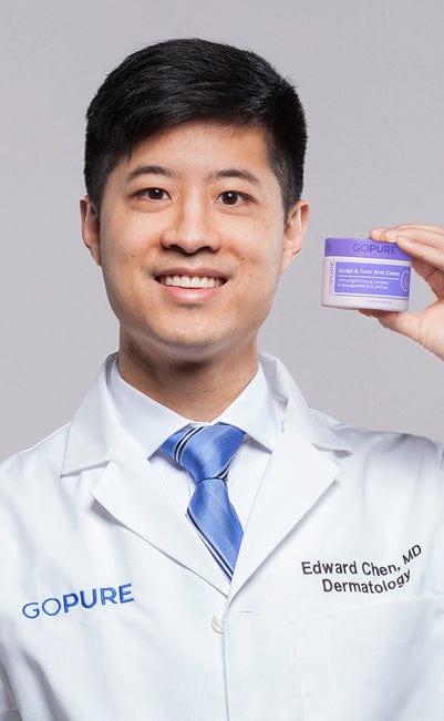 Doctor wearing a white coat with 'Edward Chen, MD Dermatology' and 'GOPURE' embroidered, holding a jar of GoPure Sculpt & Tone Arm Cream.