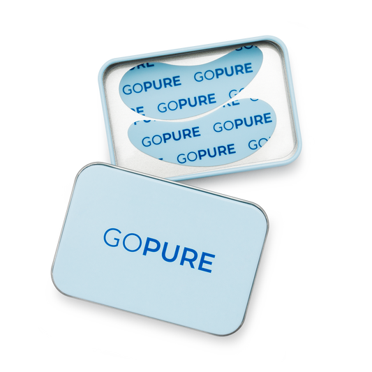 Close-up of open goPure tin showing two reusable under-eye patches in blue.