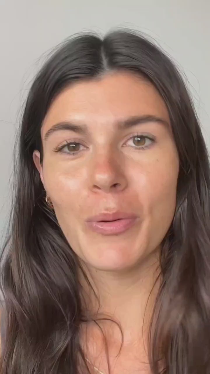 Woman with long dark hair and minimal makeup speaking directly to the camera in a well-lit indoor setting.
